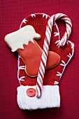 Boot biscuit and candy cane on woollen mitten