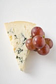 Piece of blue cheese and red grapes