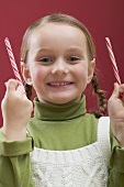 Small girl holding two candy canes