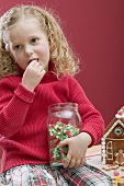 Kleines Mädchen nascht Candy Corn aus einem Vorratsglas