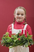 Small girl holding Advent wreath with burning candles