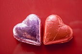 Two heart-shaped chocolates in foil