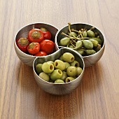 Chillies, giant capers and olives in small bowls