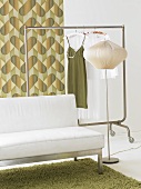 Sofa, clothes rack and standard lamp in a room