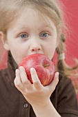 Little girl biting into apple