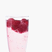 Mineral water and raspberries in glass