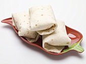 Tortilla parcels in chilli pepper shaped dish