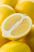 Half a lemon on several whole lemons