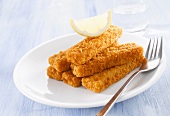 Fish fingers with lemon wedge on plate