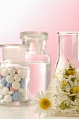 Chamomile flowers and tablets in apothecary bottles