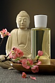 Buddha figure, scented oil and spray of cherry blossom