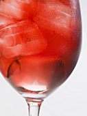 Glass of rosé wine with ice cubes (close-up)
