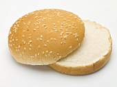 A hamburger bun with sesame seeds, split