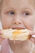 Little girl eating honey and bread