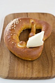 Pretzel with butter on chopping board