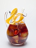 Sangria in a glass jug with orange peel
