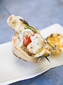 Grilled fish and vegetable skewer on toasted bread