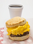 Scone filled with scrambled egg, cheese & sausage, cup of coffee