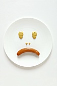 Trauriges Gesicht aus Wiener Würstchen mit Senf