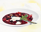 A plate of red berry compote with custard