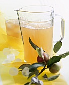 Apple juice in a glass jug and in a glass with ice cubes