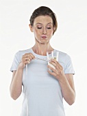 Junge Frau mit einem Glas Milch und Massband