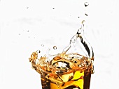 Apple juice splashing out of a glass