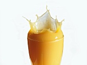 Mango nectar splashing out of a glass