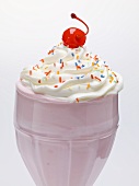 Milkshake with cream, sprinkles and cocktail cherry