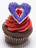 Schokoladenmuffin mit rotem Cremetupfer & blauem Herz