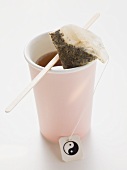 Tea in pink plastic cup with tea bag