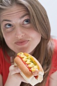 Nachdenkliche Frau mit Hot Dog