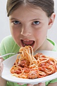 Mädchen beim Spaghetti mit Fleischklösschen essen