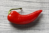 Fresh red chilli on wooden background (overhead view)