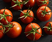 Several vine tomatoes with drops of water from above