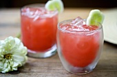 Two Watermelon Cocktails Over Ice with Cucumber Garnish