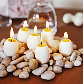 Eiförmige Kerzen auf Steinen