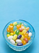 Jelly Beans in blauer Schale auf blauem Hintergrund