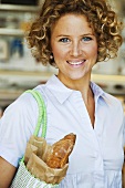 Frau kauft Brot im Supermarkt