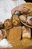 Baker with various types of bread and bread rolls