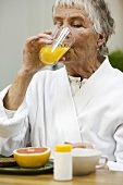 Elderly woman drinking orange juice