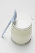 Natural yoghurt in jar, plastic spoon