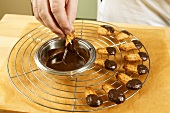 Dipping wholefood piped biscuits in melted chocolate