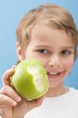 Little boy holding a partly eaten apple