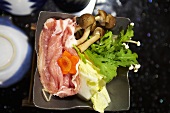 Ingredients for sukiyaki (pork, cabbage, enoki mushrooms and carrots)