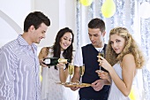 Junge Leute trinken Champagner auf einer Party