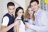 Junge Leute trinken Cocktails auf einer Party