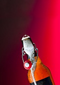 Flip-top beer bottle with beer frothing out