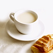 Tasse Milch und Blätterteiggebäck
