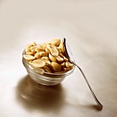 Salted peanuts in glass dish with spoon